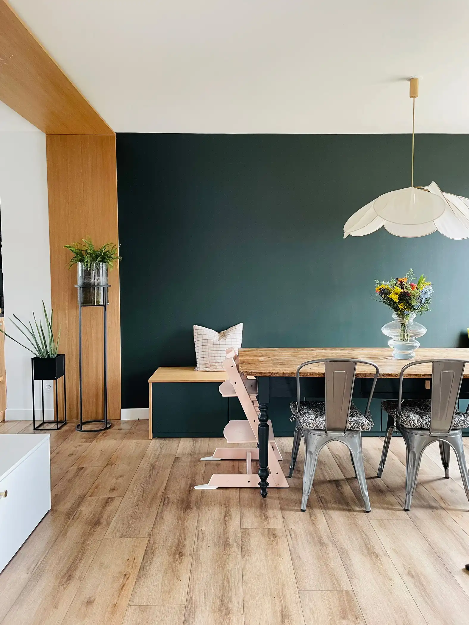 Salle à manger avec un beau vert profond, sa suspension aérienne et son mobilier rétro dans une belle ambiance maison de campagne moderne.