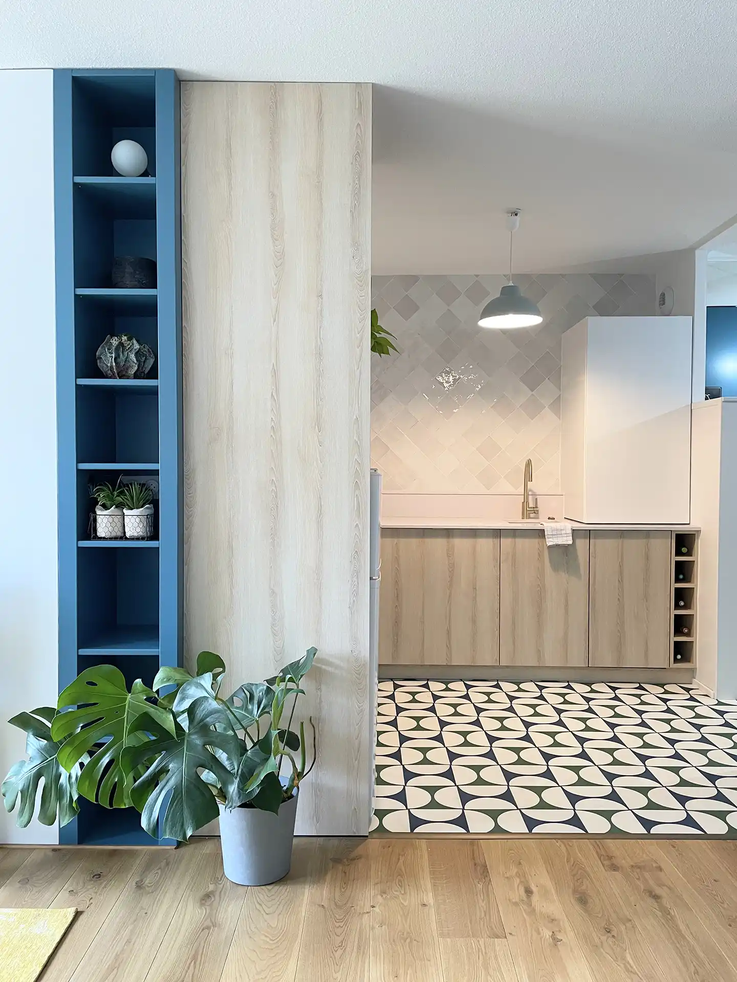 Cuisine blanc et bois avec un sol très original de carreaux de ciment moderne et graphique bleu et vert.