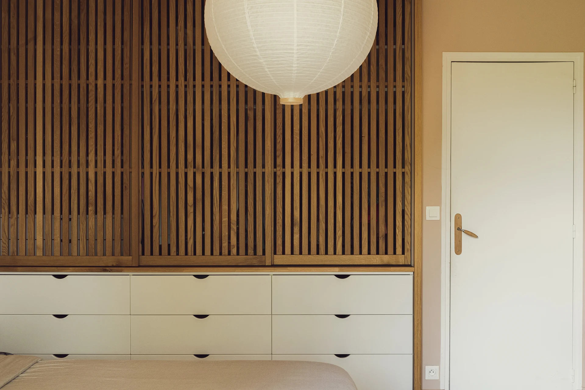 Placard bois en chêne, magnifiques panneaux coulissants sur meuble blanc à tiroir dessiné sur-mesure par Paulette intérieurs.