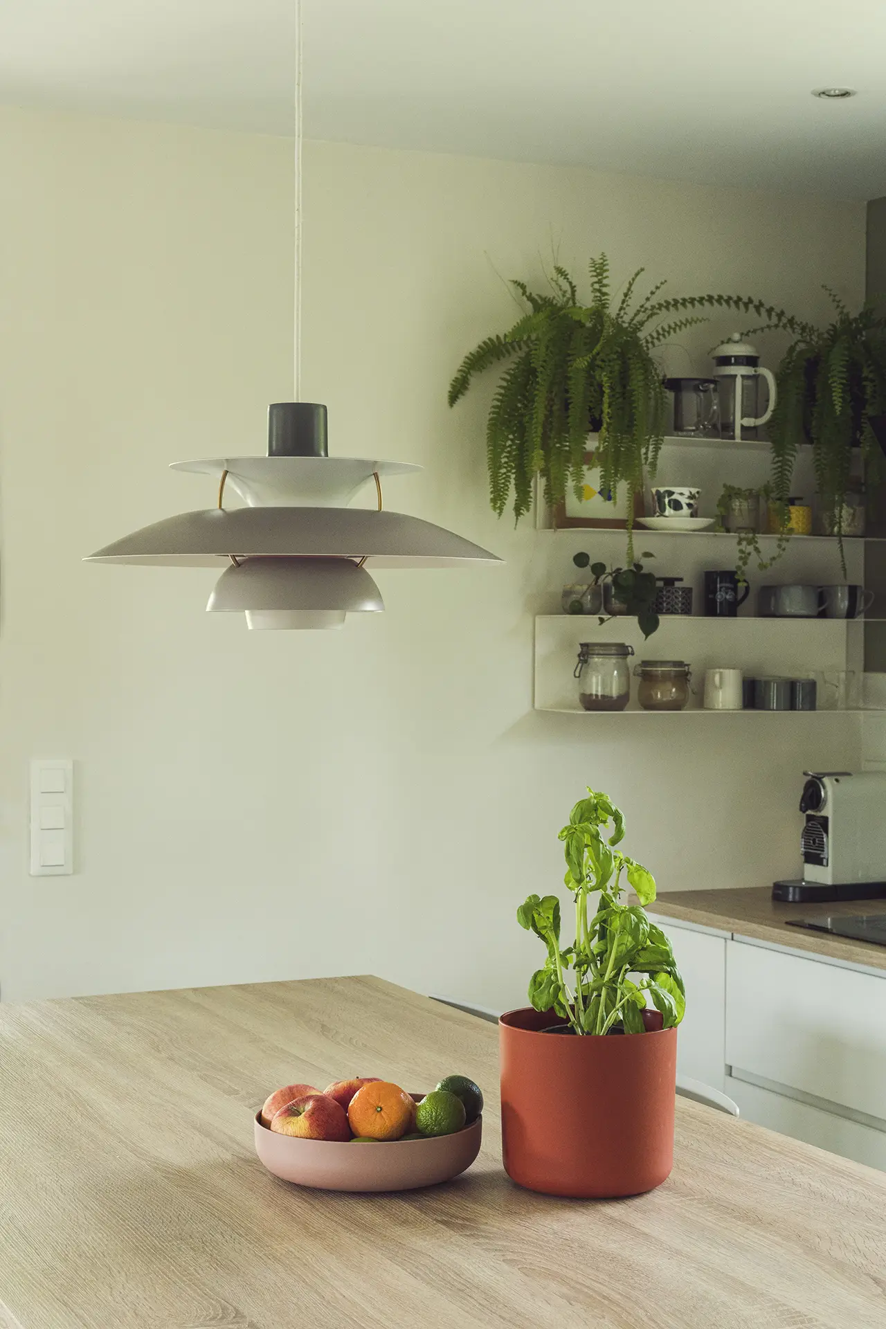 Cuisine blanc et bois épurée avec une belle suspension au style danois.