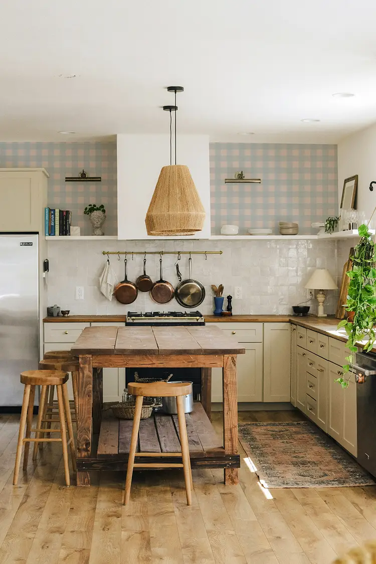 Photo d'une cuisine de campagne avec son mobilier ancien, sa crédence en zellige et du papier peint vichy bleu aux murs.