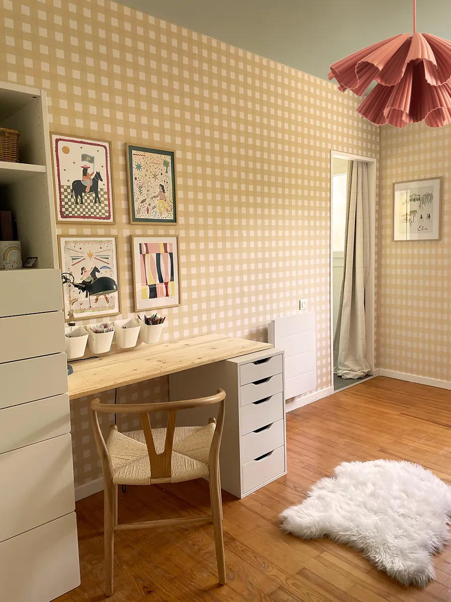 Papier peint vichy dans un jaune presque sable, associé à une peinture céladon qui conne à cette chambre d'enfant un cocon chaleureux.