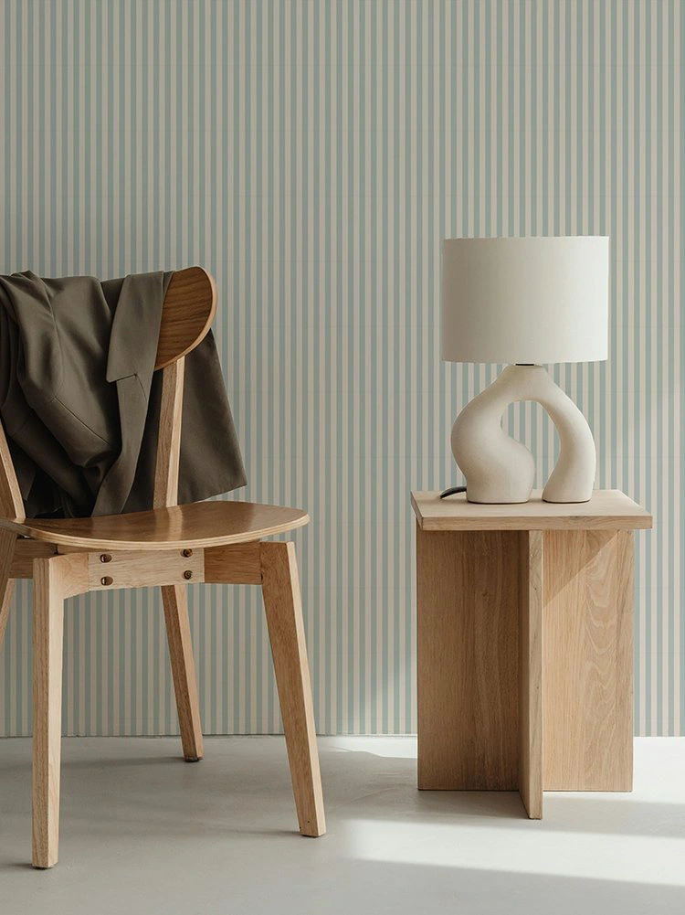 Papier peint à rayures fines beige et céladon pour une intérieur frais s'associant parfaitement avec le bois pour un style scandinave.