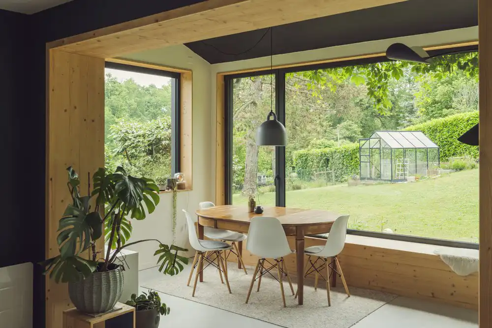 Photo d'une extension de maison dans une style scandinave avec son sol en béton ciré et ses touches de bois.