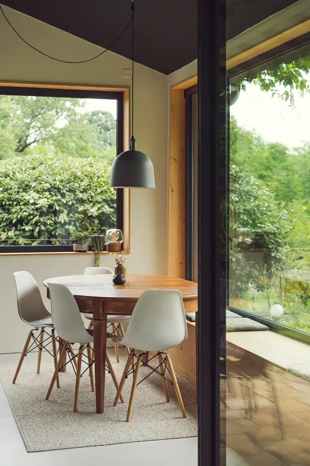 Photo d'une salle à manger dans une belle pièce vitrée dans un style scandinave ouvrant vers un jardin luxuriant.