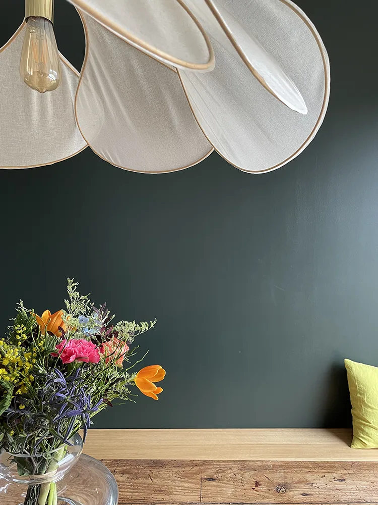 Photo d'une terrasse entourée de nature avec son mobilier en métal gris anthracite qui fait ressortir le vert de la nature environnante.