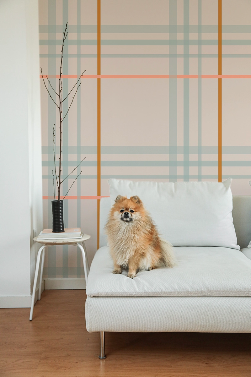 Papier peint éco-responsable à grands carreaux dans des tons doux de beige, rose bleu et brun dans un style tartan.
