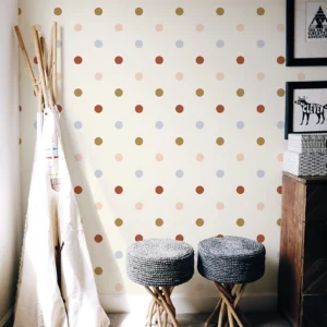 Papier peint à pois rose, ocre, bleu tendre et terracotta, idéal pour une chambre d'enfant avec du caractère mais tout en restant épurée.