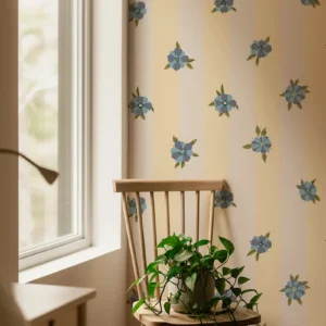 Papier peint combinant un motif floral dans les bleus sur un fond à rayure jaune et beige.
