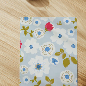 Echantillon du papier peint floral Eugénie frais et délicat sur fond bleu poudré.