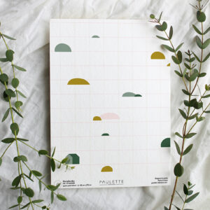Echantillon du papier peint à carreaux Homelandes avec son quadrillage style feuille d'écolier et ses petites montagnes colorées.