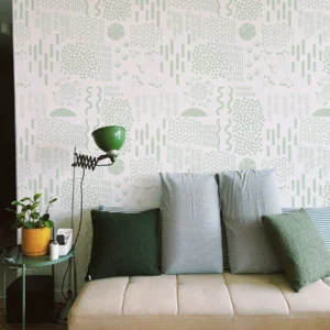 Papier peint blanc et vert d’eau avec des symboles d’art primitif donnant une ambiance fraiche et ethnique.