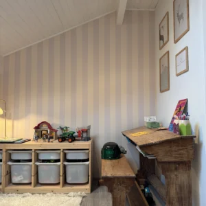 Papier peint à rayures verticales blanc crème et jaune idéal pour une chambre d'enfant.