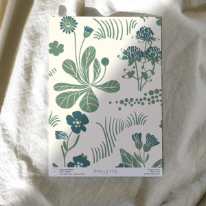 Echantillon de papier peint intissé du motif Léon de fleurs de jardin bleues et vertes sur fond beige.
